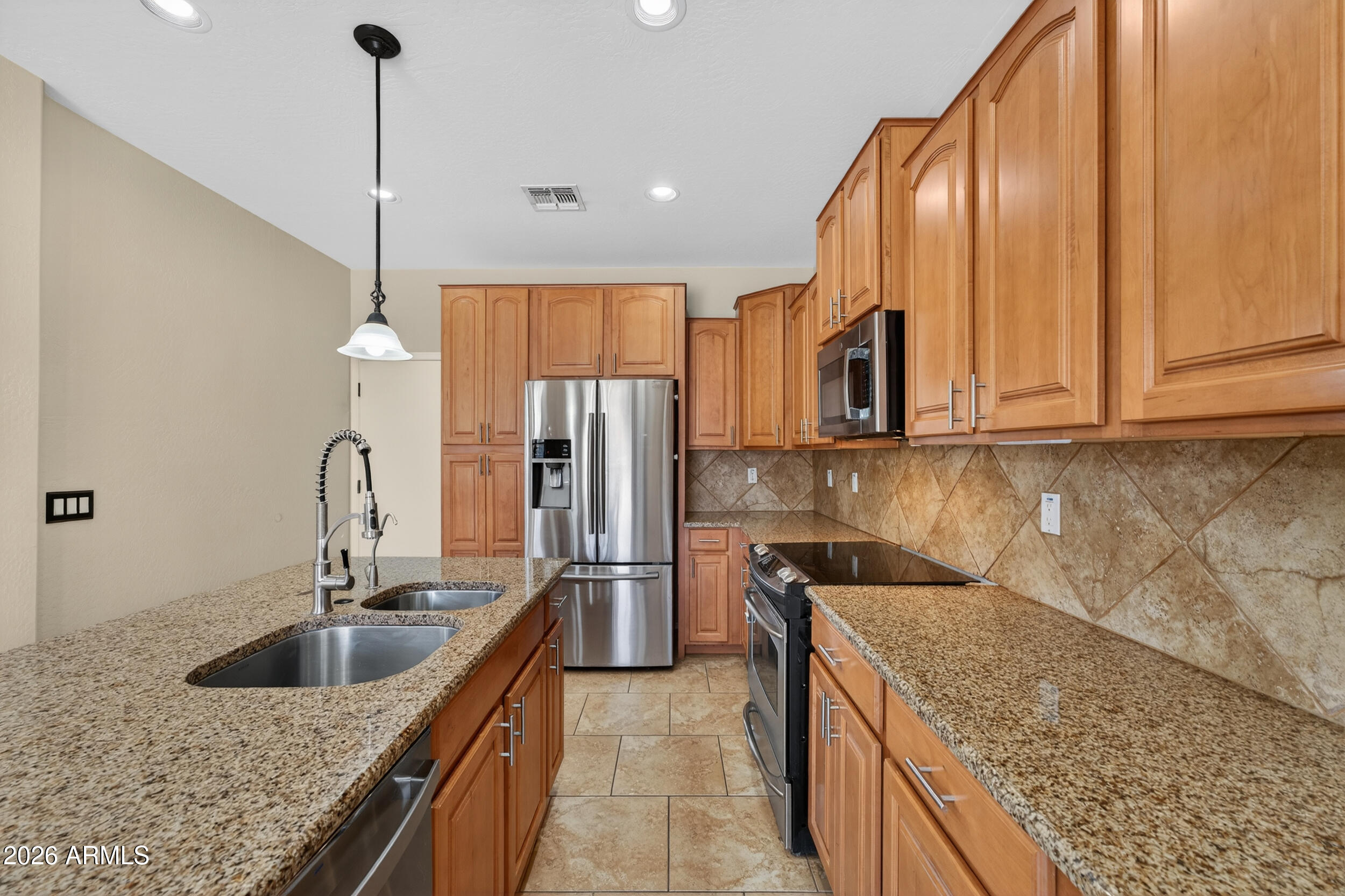 4199 North 154th Drive Goodyear, AZ 85395 - Photo 2 of 17 a kitchen with stainless steel appliances granite countertop a sink a microwave and island