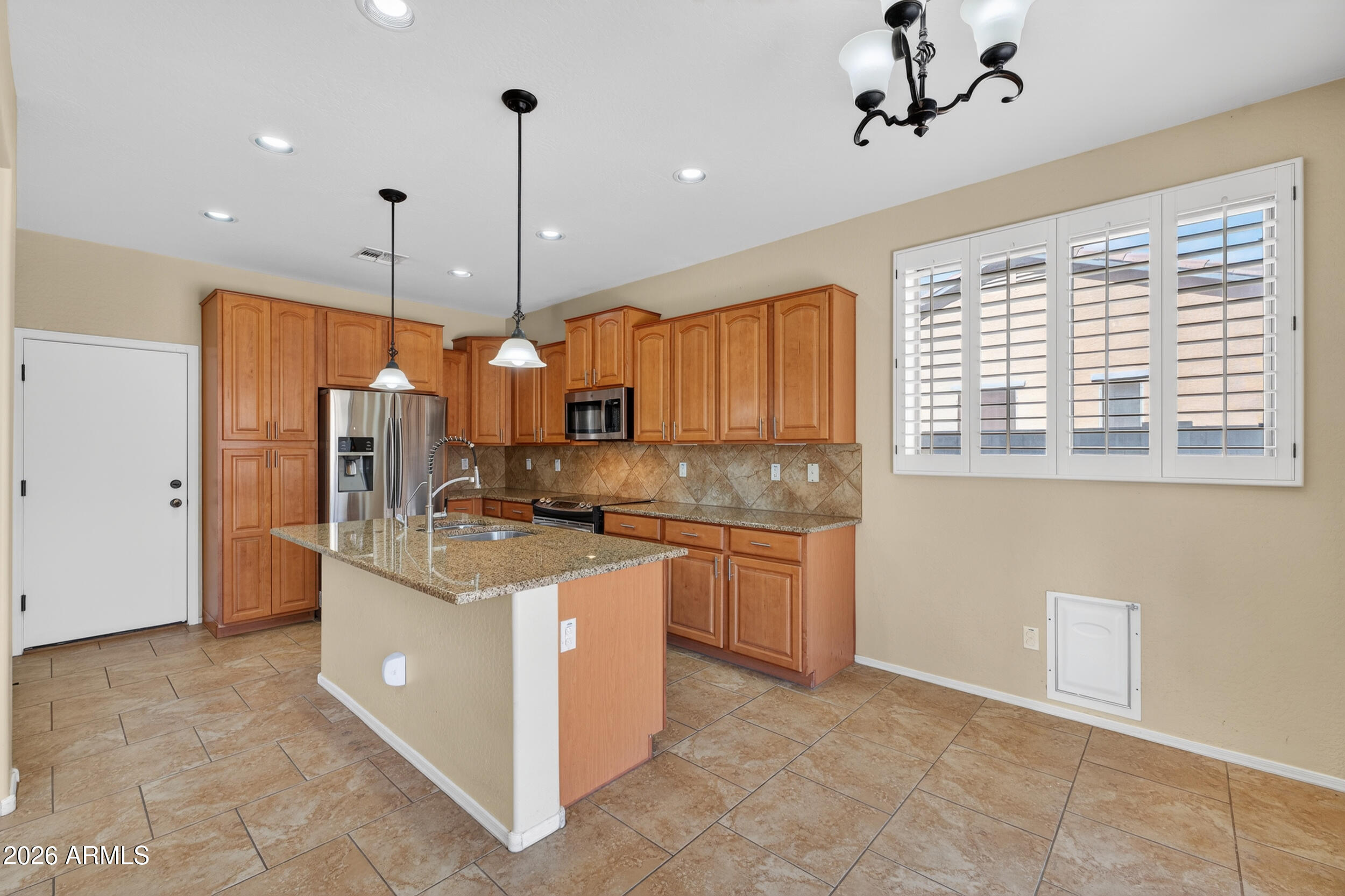 4199 North 154th Drive Goodyear, AZ 85395 - Photo 3 of 17 a kitchen with stainless steel appliances granite countertop a refrigerator a oven and a sink