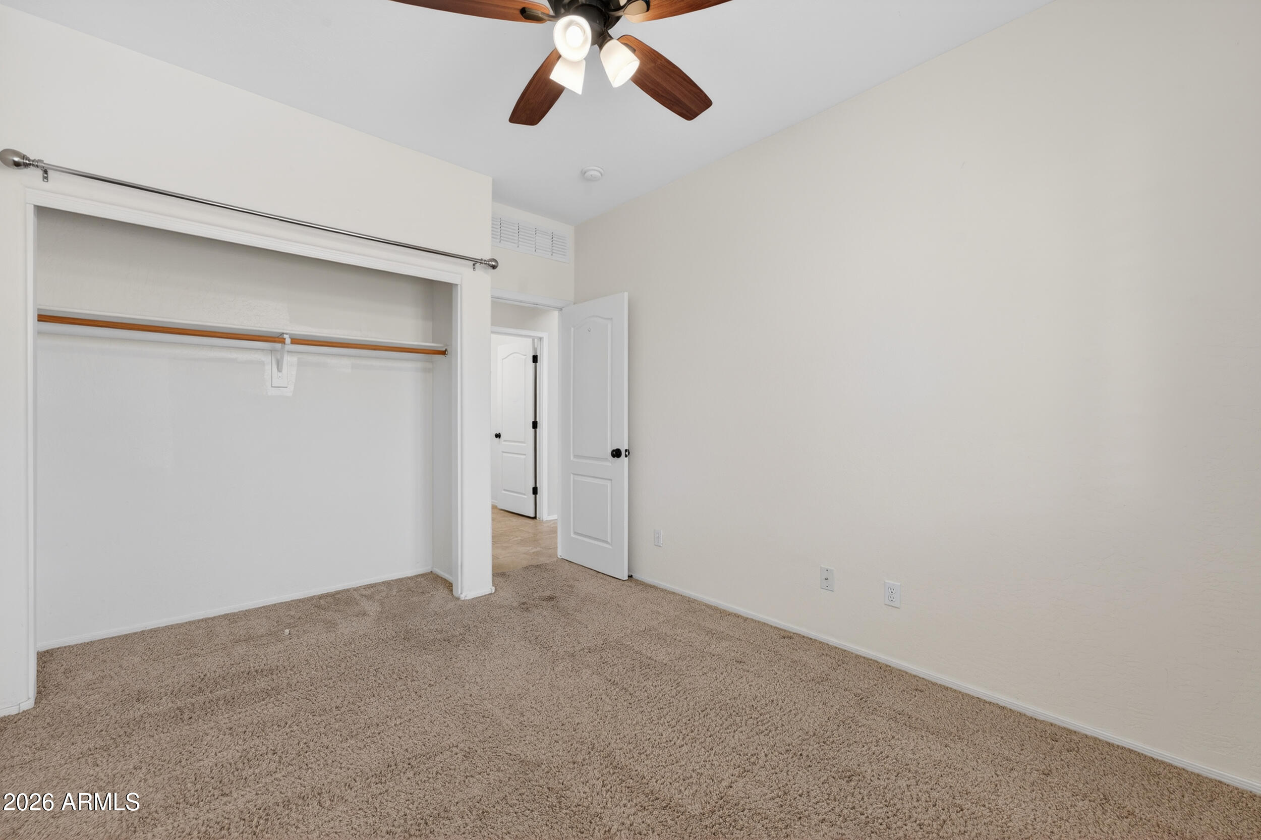 4199 North 154th Drive Goodyear, AZ 85395 - Photo 6 of 17 an empty room with a ceiling fan and carpet