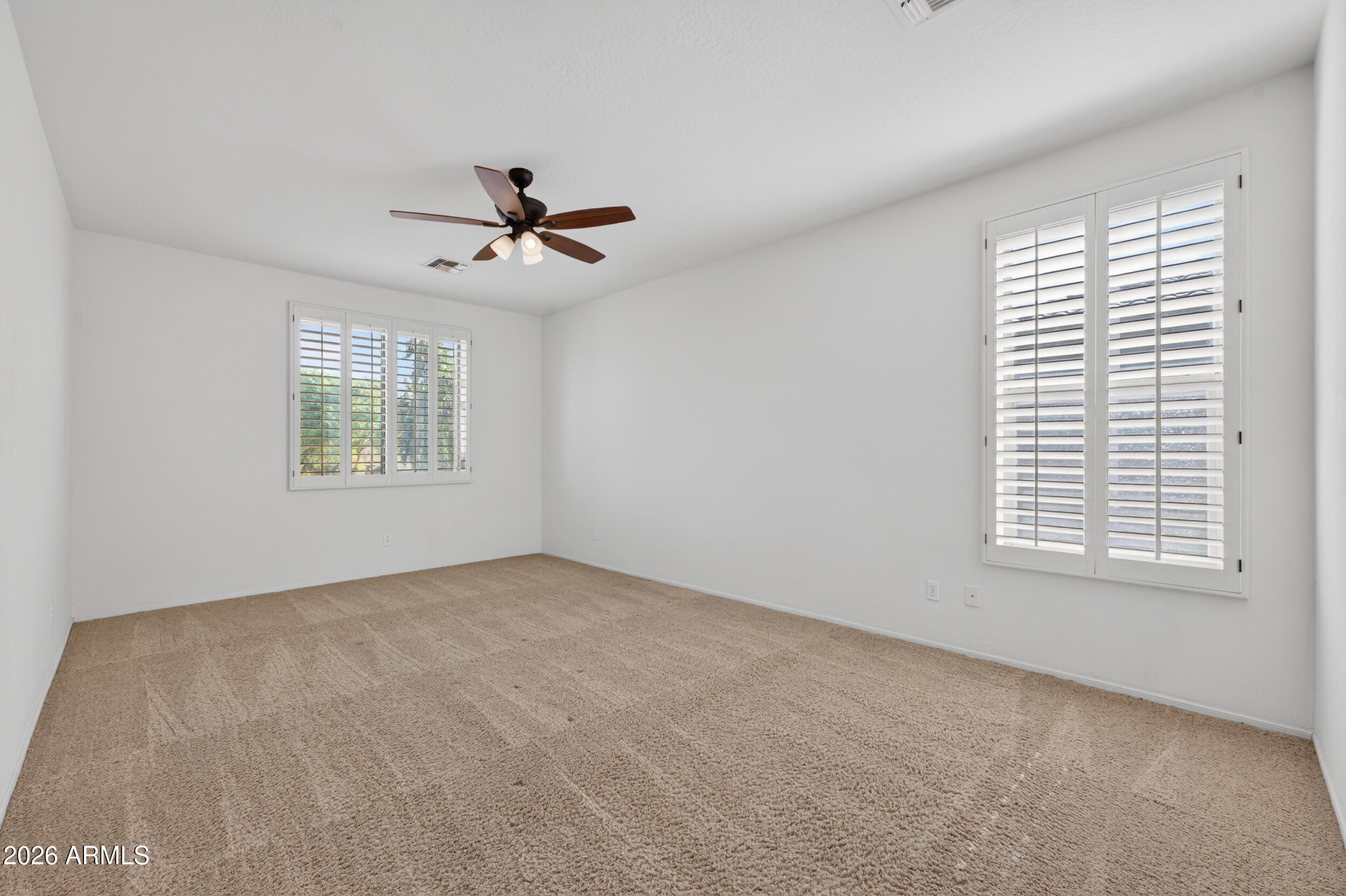 4199 North 154th Drive Goodyear, AZ 85395 - Photo 7 of 17 an empty room with windows and fan