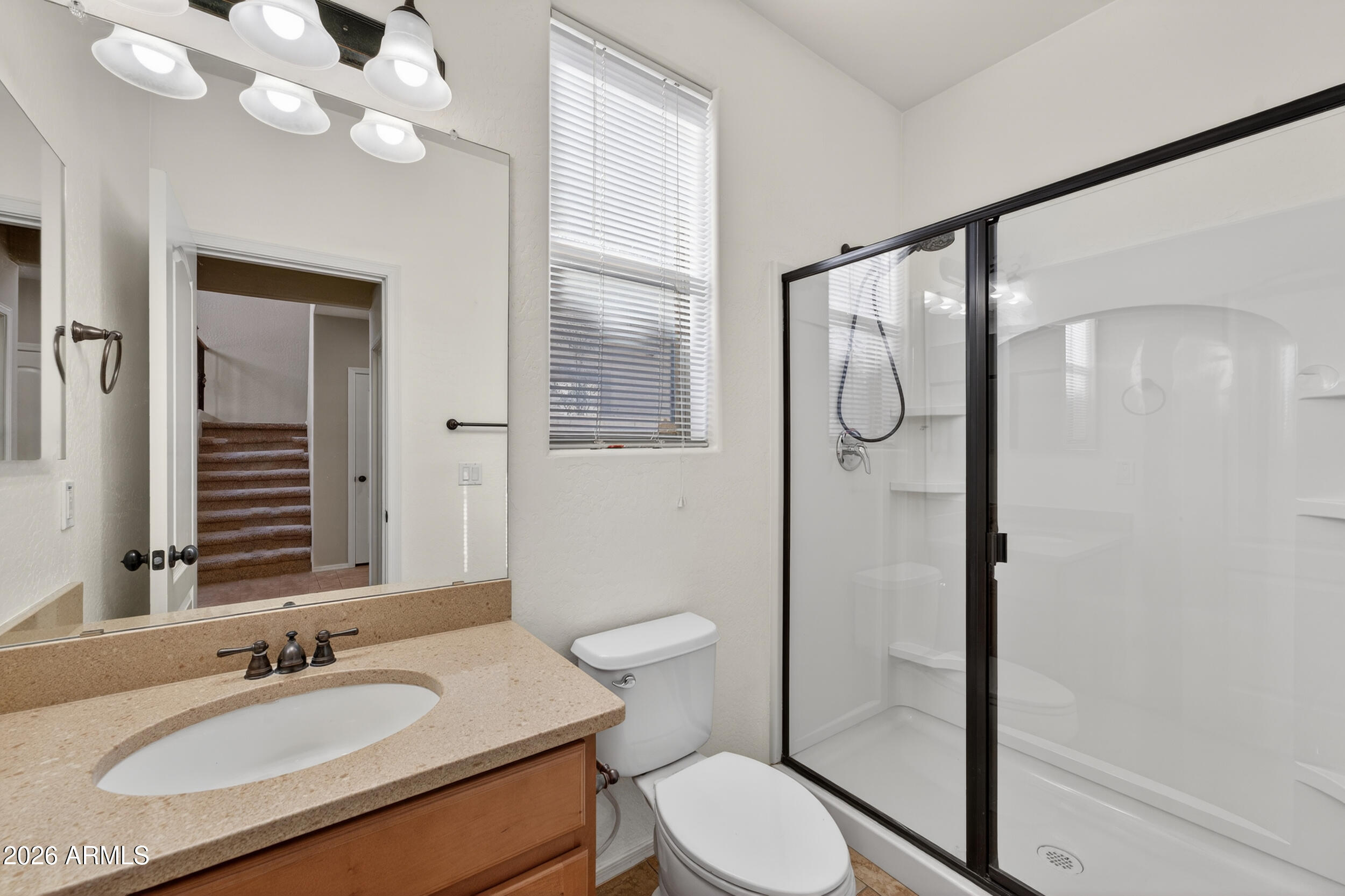 4199 North 154th Drive Goodyear, AZ 85395 - Photo 10 of 17 a bathroom with a granite countertop sink mirror vanity and toilet