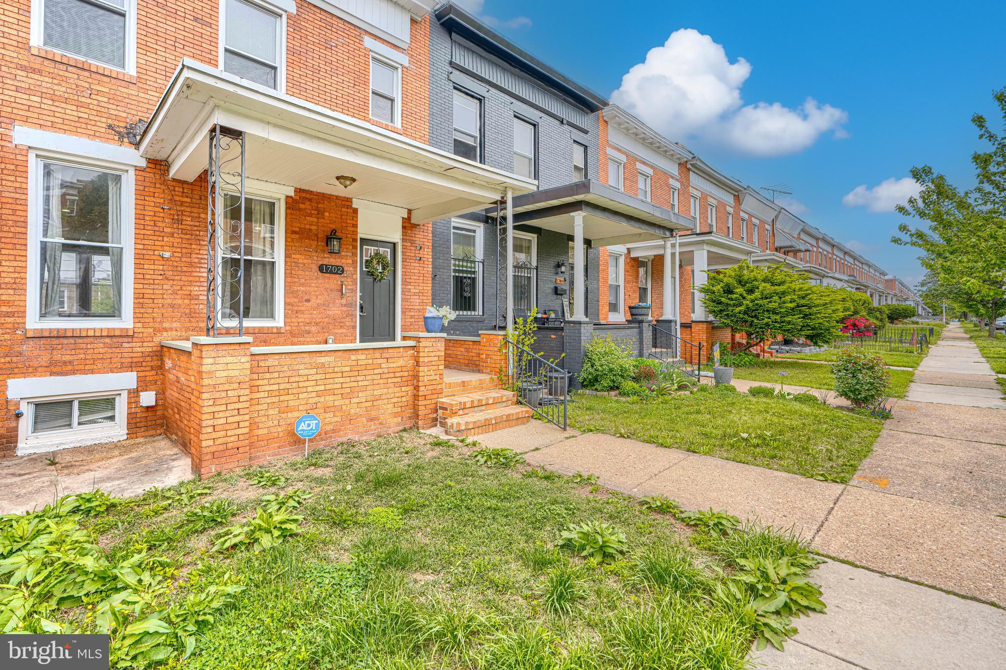 1702 East 32nd Street Baltimore, MD 21218 - Photo 3 of 38 front view of a brick house with a yard