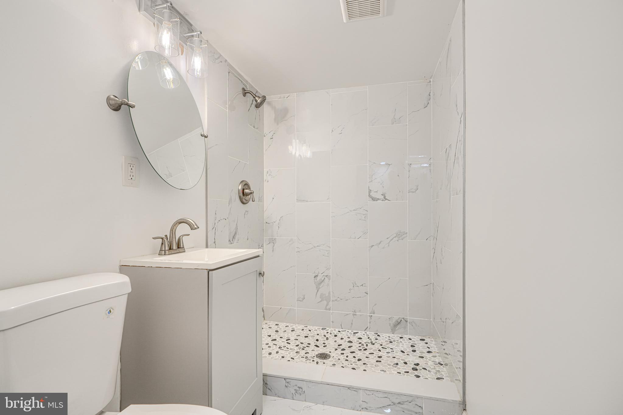 1702 East 32nd Street Baltimore, MD 21218 - Photo 35 of 38 a bathroom with a sink a toilet and shower