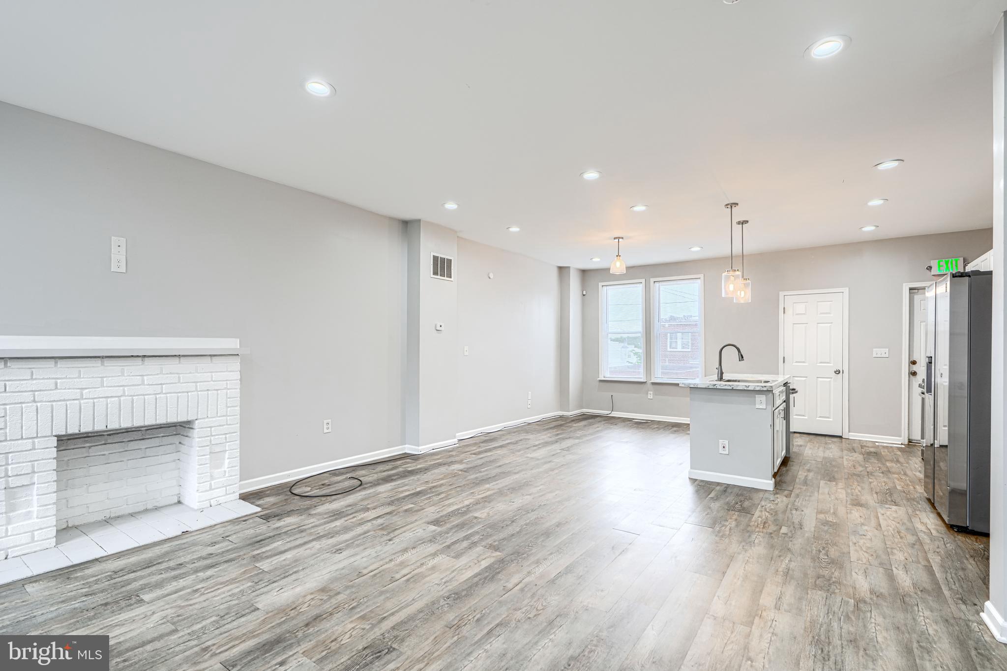 1702 East 32nd Street Baltimore, MD 21218 - Photo 5 of 38 a view of empty room with wooden floor and fireplace