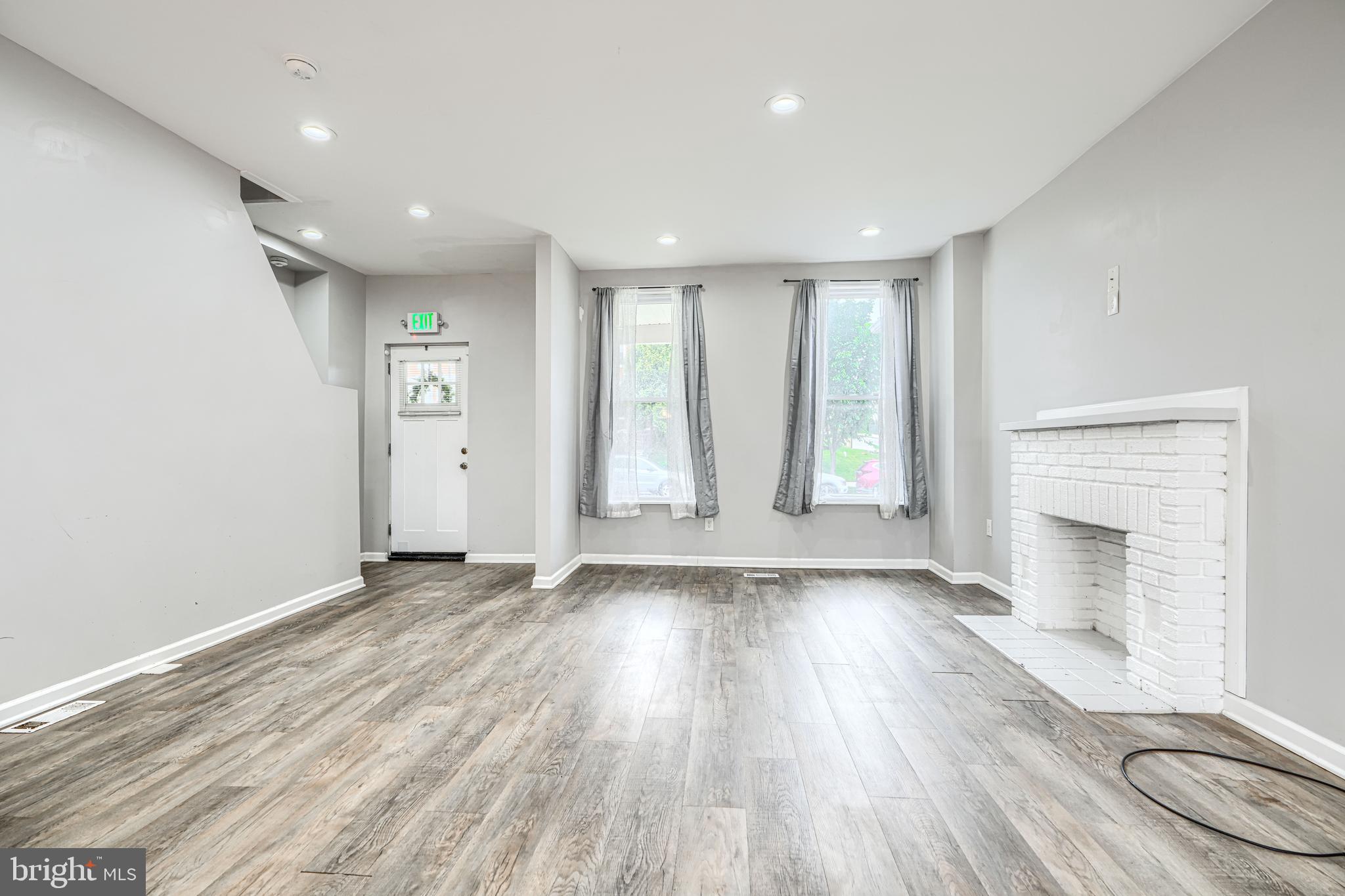 1702 East 32nd Street Baltimore, MD 21218 - Photo 8 of 38 an empty room with wooden floor and windows