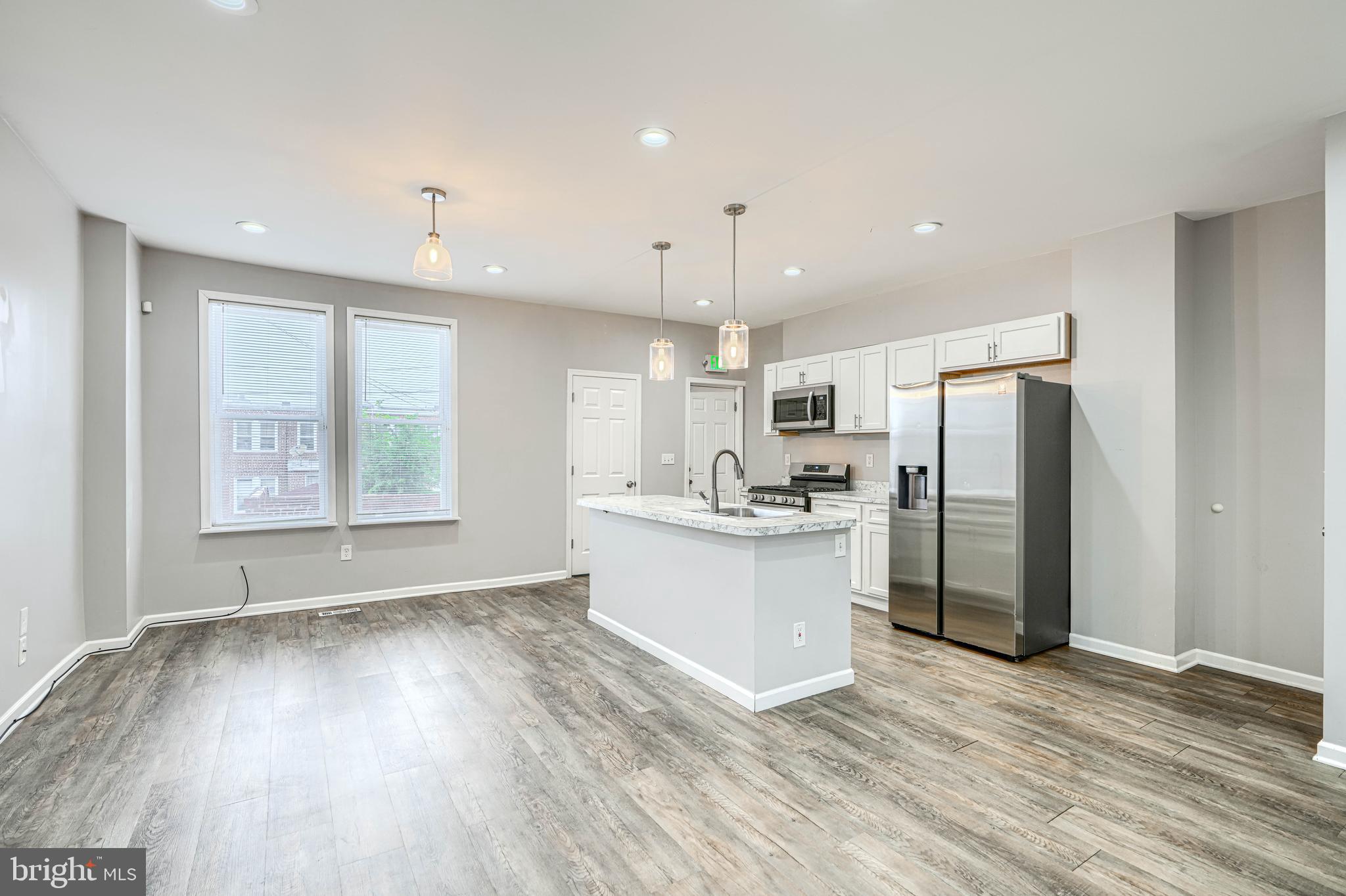 1702 East 32nd Street Baltimore, MD 21218 - Photo 9 of 38 a view of kitchen with stainless steel appliances refrigerator oven stove and wooden floor
