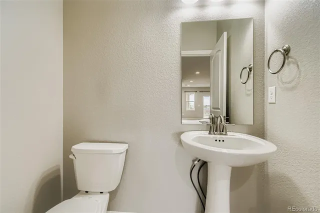 a bathroom with a toilet sink and mirror