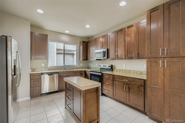 a kitchen with stainless steel appliances granite countertop a stove top oven sink and cabinets