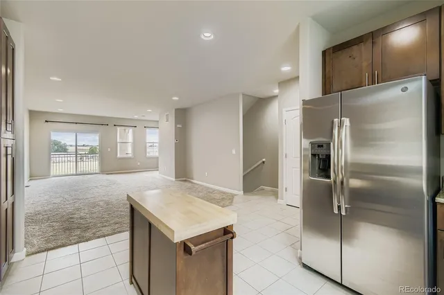 a kitchen with granite countertop a refrigerator and a sink