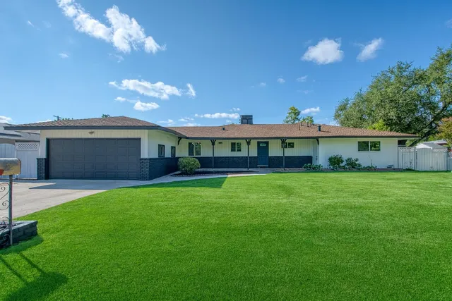 a front view of a house with a garden and yard
