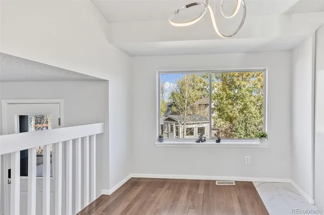 a view of a room with wooden floor and windows
