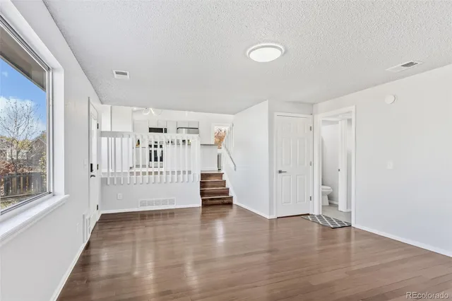 a view of a livingroom with wooden floor and white walls