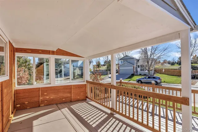 a porch with a bench next to a yard