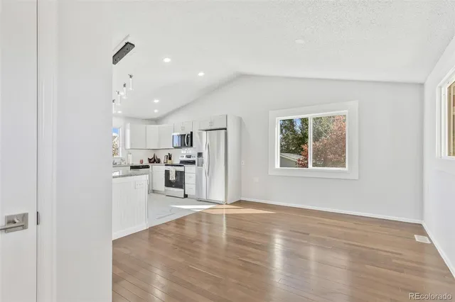 a view of a kitchen with wooden floor and a window