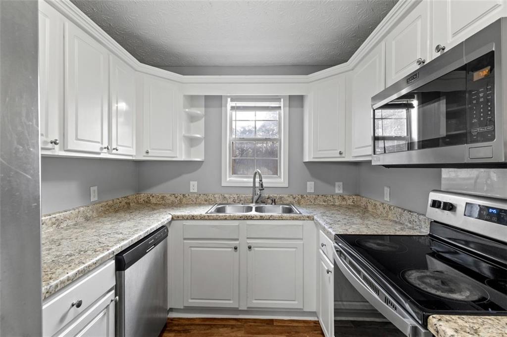 418 Ellerbe Drive Statham, GA 30666 - Photo 12 of 24 a kitchen with stainless steel appliances granite countertop a sink stove and cabinets