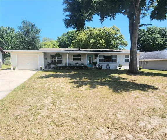 a view of a house with a yard and sitting area