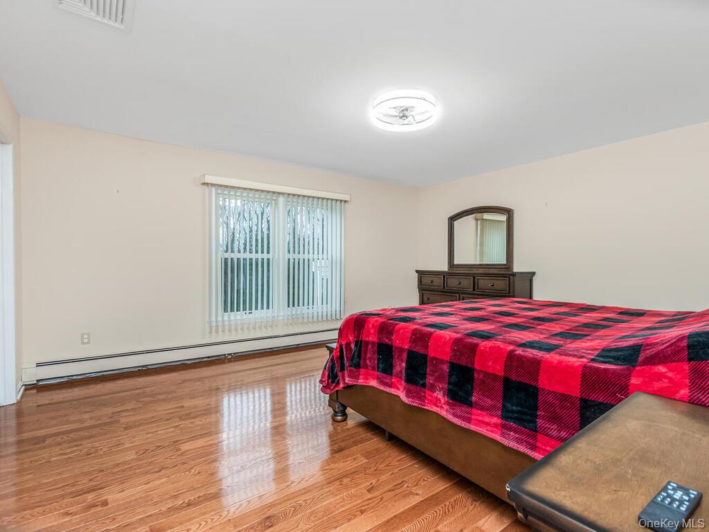 70 Breckenridge Road Mahopac, NY 10541 - Photo 20 of 29 Bedroom featuring a baseboard heating unit and wood finished floors