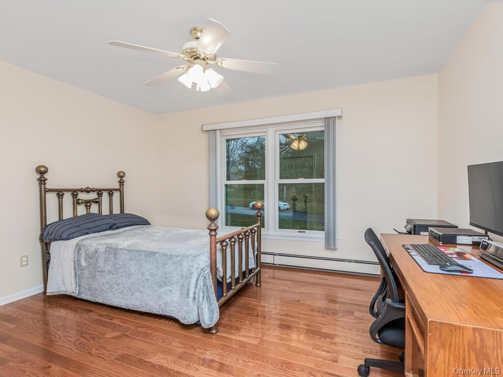 70 Breckenridge Road Mahopac, NY 10541 - Photo 22 of 29 Bedroom featuring an office area, baseboard heating, ceiling fan, and wood finished floors