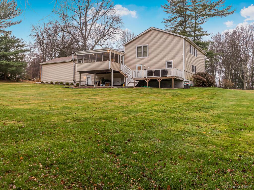70 Breckenridge Road Mahopac, NY 10541 - Photo 23 of 29 Rear view of property featuring a sunroom, a lawn, stairs, and a wooden deck