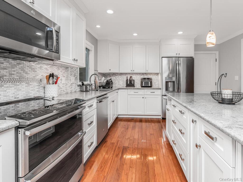 70 Breckenridge Road Mahopac, NY 10541 - Photo 4 of 29 Kitchen with stainless steel appliances, white cabinets, ornamental molding, light stone countertops, and recessed lighting