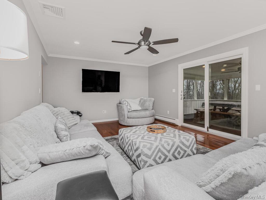 70 Breckenridge Road Mahopac, NY 10541 - Photo 7 of 29 Living area with crown molding, ceiling fan, baseboard heating, wood finished floors, and recessed lighting