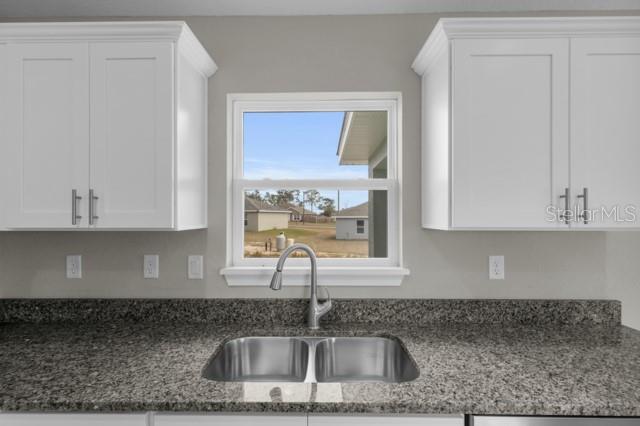 25 Locust Loop Lane Ocala, FL 34472 - Photo 11 of 35 a kitchen with granite countertop a sink a stove and cabinets