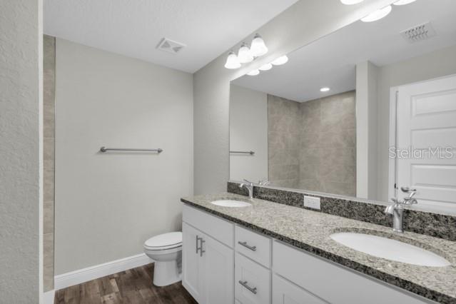 25 Locust Loop Lane Ocala, FL 34472 - Photo 17 of 35 a bathroom with a granite countertop sink a toilet and a mirror