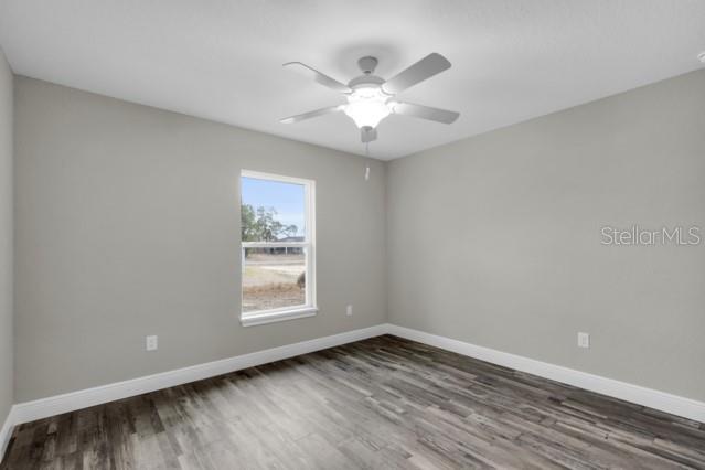 25 Locust Loop Lane Ocala, FL 34472 - Photo 19 of 35 a view of an empty room with wooden floor and a window