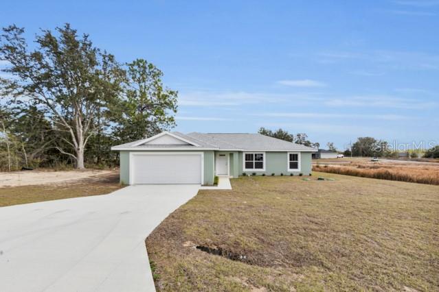 25 Locust Loop Lane Ocala, FL 34472 - Photo 31 of 35 a front view of a house with a yard and trees
