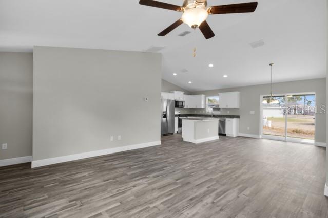 25 Locust Loop Lane Ocala, FL 34472 - Photo 5 of 35 a view of an empty room with wooden floor and a ceiling fan