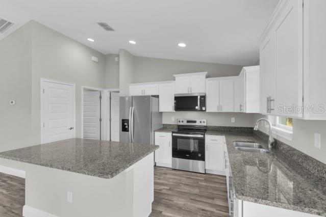 25 Locust Loop Lane Ocala, FL 34472 - Photo 9 of 35 a kitchen with stainless steel appliances granite countertop a stove top oven a sink and a refrigerator