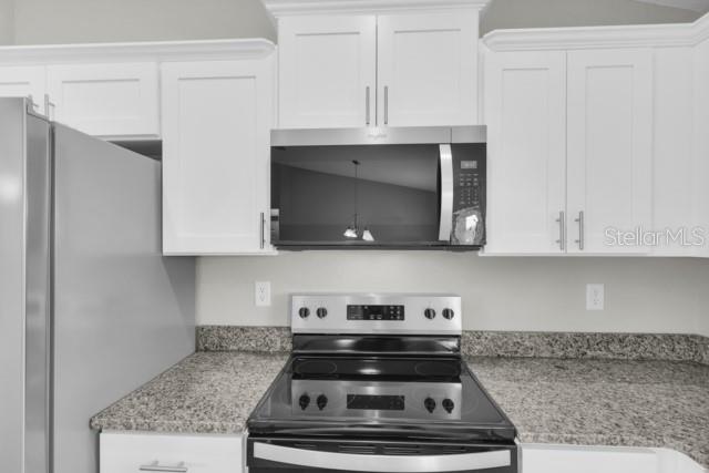 25 Locust Loop Lane Ocala, FL 34472 - Photo 10 of 35 a stove top oven sitting inside of a kitchen