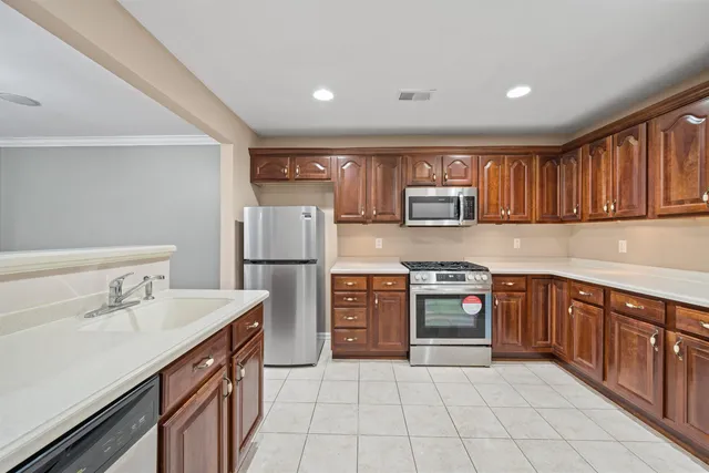 a kitchen with stainless steel appliances granite countertop a stove top oven a sink and dishwasher