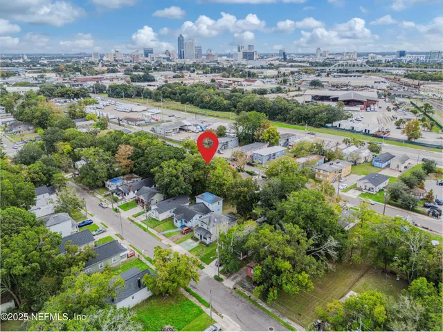 an aerial view of residential houses with outdoor space and trees