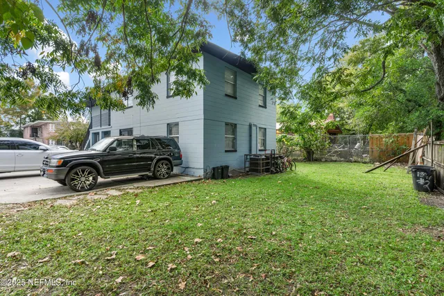 a view of a house with a big yard and large trees