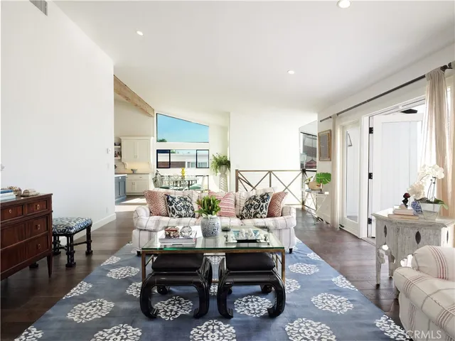 a living room with furniture a rug a fireplace and a window