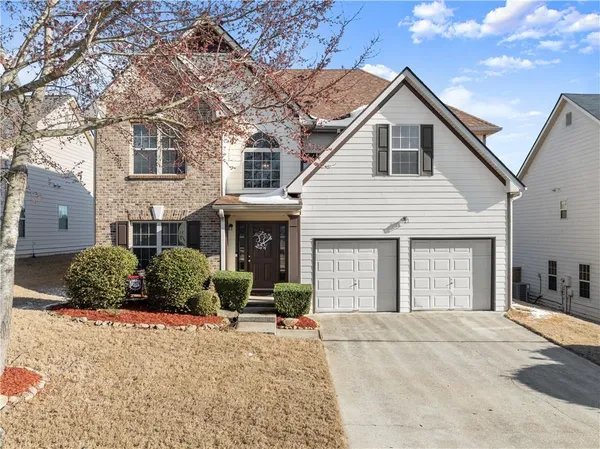 a front view of a house with a yard and garage