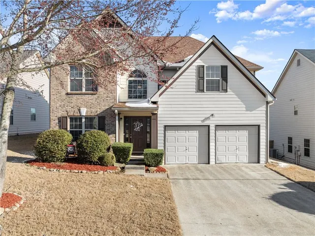 a front view of a house with a yard and garage