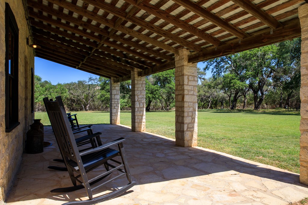 268 Marschall Creek Road Fredericksburg, TX 78624 - Photo 47 of 77 a view of a patio with a table chairs and a backyard