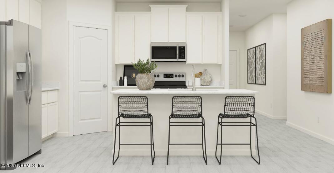 460 Hasler Avenue St. Augustine, FL 32092 - Photo 21 of 37 a white kitchen with stainless steel appliances granite countertop a stove a sink a microwave a refrigerator and white cabinets