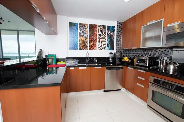 a kitchen with stainless steel appliances granite countertop a stove a sink and a microwave
