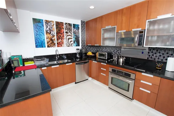 a kitchen with stainless steel appliances granite countertop a stove a sink and a microwave