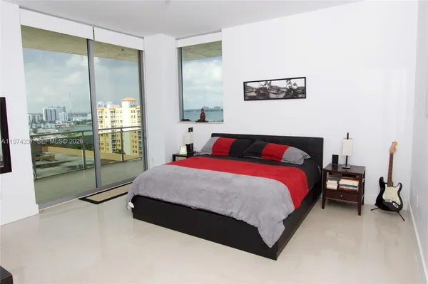 a bedroom with a large bed and a balcony view