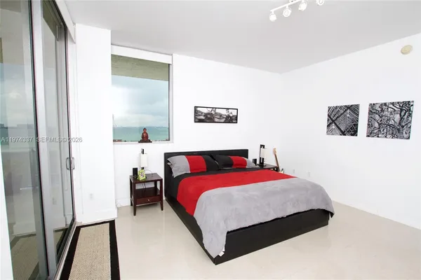 a bedroom with a bed and a painting on the wall