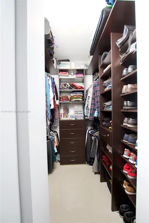a view of walk in closet with clothes and shoes