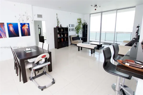 a living room with furniture and a floor to ceiling window