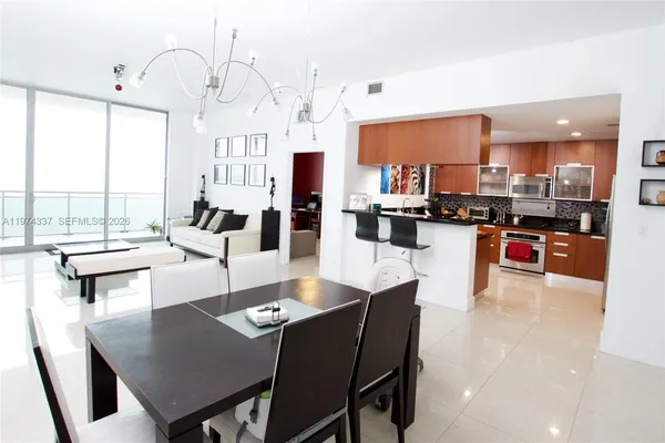a living room with stainless steel appliances kitchen island granite countertop a dining table chairs and a dining table view