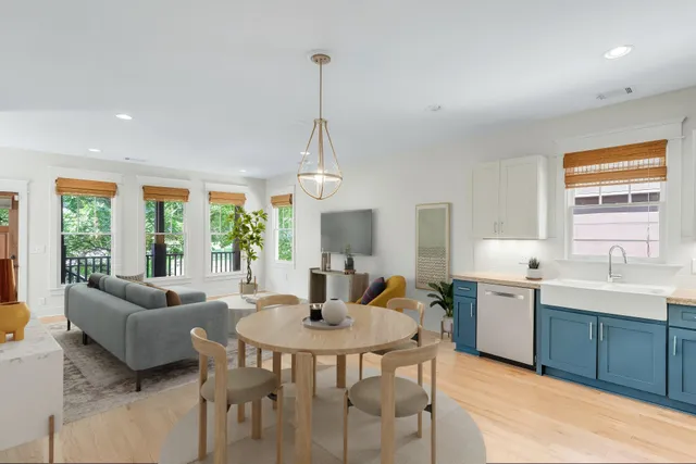 a kitchen with a dining table chairs and white cabinets
