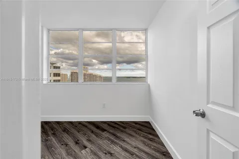 a view of a room with wooden floor and a window