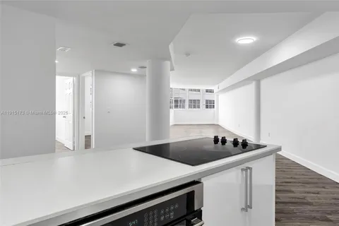 a kitchen that has a sink a stove and cabinets